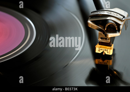 Testa di lettura Shure, posizionata su un disco in vinile nero, che ruota su un lettore di dischi. Foto Stock