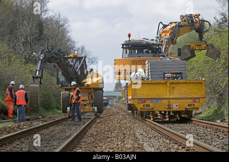 Specialista contraente utilizzando road-veicoli ferroviari a scavare e sostituire obsoleti via sistema di drenaggio su una trafficata della rete ferroviaria. Foto Stock