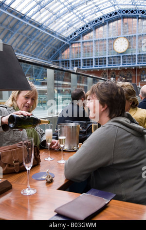 Bevitori femmina presso lo Champagne bar a Kings Cross Saint Pancras Eurostar Channel tunnel di collegamento stazione internazionale. Londra REGNO UNITO. Foto Stock