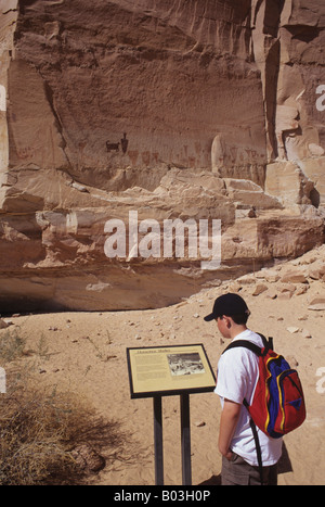 Ragazzo lettura segno sui pittogrammi a ferro di cavallo Shelter in Horseshoe Canyon, il Parco Nazionale di Canyonlands, Utah Foto Stock