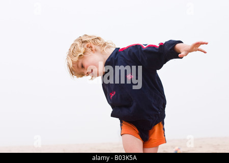 Ragazzo biondo sulla spiaggia misty, Lielupe, Lettonia Foto Stock