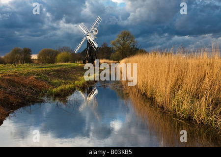 Legname Boardmans aprire incorniciato windmill riflettendo in una diga su Norfolk Broads con una tempesta che ci passa sopra la testa. Foto Stock