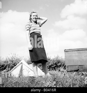 Vecchia famiglia vintage fotografia istantanea di attraente giovane donna bionda in piedi nella parte anteriore della tenda in vacanza CAMPEGGIO Foto Stock