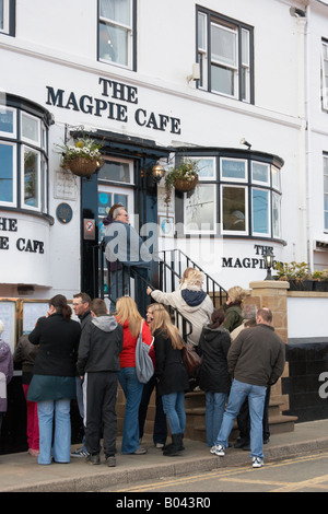 La gente in coda al di fuori del famoso 'Magpie cafe' a Whitby, North Yorkshire, Inghilterra, Regno Unito. Foto Stock