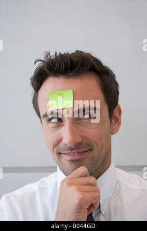 Uomo con punto interrogativo sulla sua fronte Foto Stock