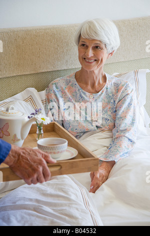 Un anziano uomo portando una donna senior prima colazione Foto Stock