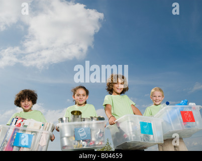 Bambini che portano scatole di riciclaggio Foto Stock