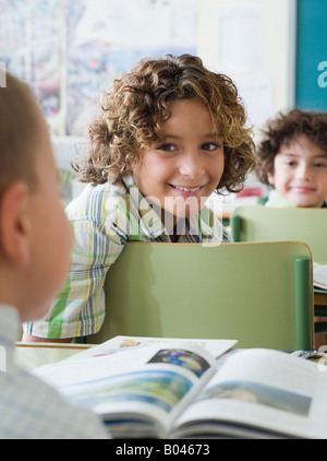 I bambini seduti in una lezione Foto Stock