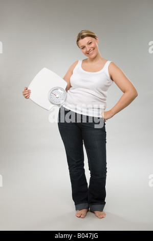 Una donna azienda bilance pesapersone Foto Stock