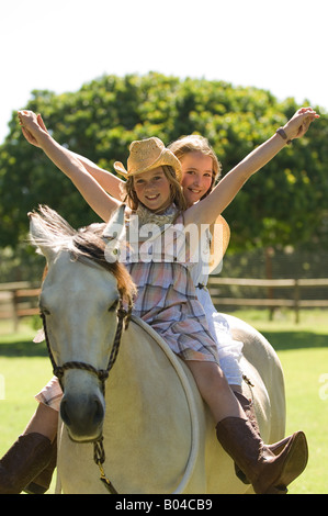 Due ragazze in sella ad un cavallo Foto Stock