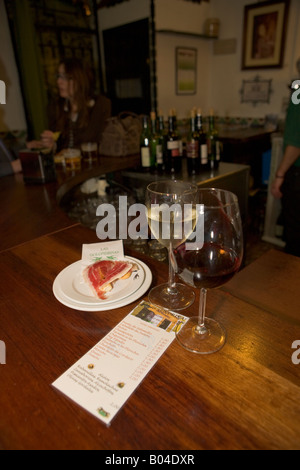 Tapas - jamon y pan (prosciutto crudo e pane) e bicchieri vino al ristorante/bar nel quartiere di Triana, città di Siviglia Foto Stock