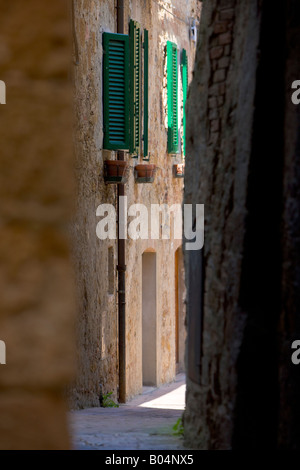 Una stretta viuzza tra vecchie case di pietra nel centro storico di Pienza, un sito Patrimonio Mondiale dell'UNESCO Foto Stock