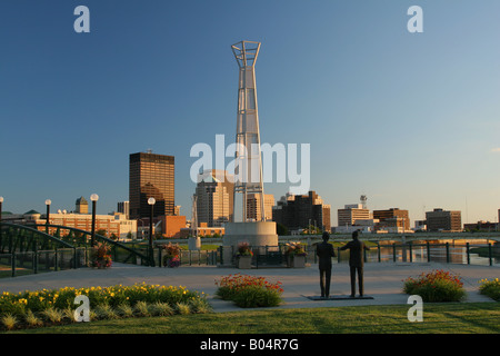 Downtown Dayton Ohio al crepuscolo. La dimensione della vita dei fratelli Wright statua in primo piano. La luce laser show tower nel centro. Foto Stock