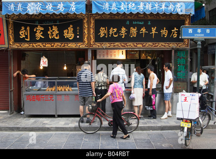 Persone che acquistano la carne nel Quartiere Musulmano, Xian, Cina Foto Stock