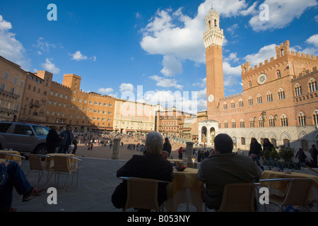 Cafe in Piazza del Campo con una vista del Palazzo Pubblico (Municipio) e la Torre del Mangia, un sito Patrimonio Mondiale dell'UNESCO Foto Stock