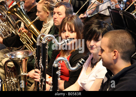 Due giovani donne bass clarinettists guardare esclusivamente a un giovane maschio clarinettista Foto Stock