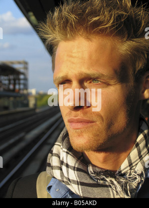 Ritratto di un giovane uomo biondo con gli occhi verdi, alla metropolitana i brani in background, STATI UNITI D'AMERICA, USA, nello stato di New York Foto Stock