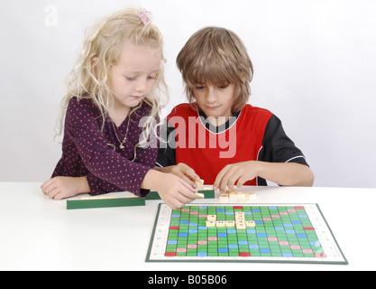 Sorella e fratello insieme giocando a Scrabble Foto Stock