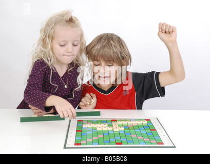 Sorella e fratello insieme giocando a Scrabble Foto Stock