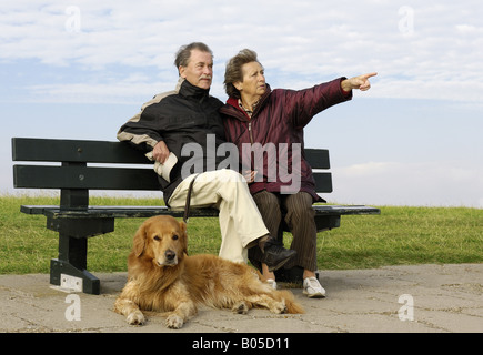 Hovawart (Canis lupus f. familiaris), Coppia senior con il cane seduto sul banco di lavoro Foto Stock