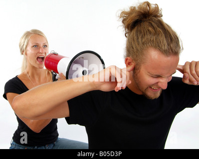 Simbolico per contenzioso civile, giovane donna che piange al megafono, uomo mantenendo i suoi orecchi chiusi Foto Stock