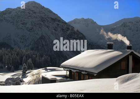 Piccola casa di montagna in un bellissimo paesaggio invernale in Arosa, Switzerland Foto Stock