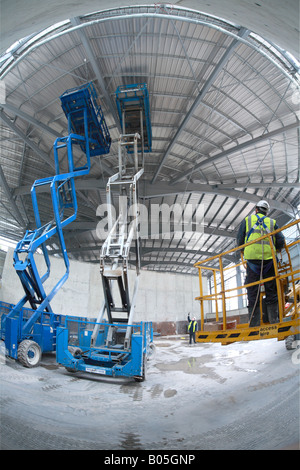 Forbici due piattaforme di sollevamento esteso per lavorare sul tetto in acciaio con builder in un cherry picker Foto Stock