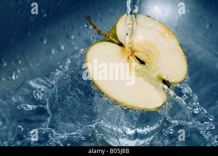 L'acqua che cade su metà fette di mela Foto Stock