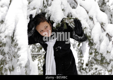 Giovane donna giocando in un parco invernale Foto Stock