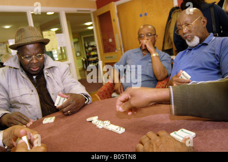 Le persone anziane GIOCA Domino a un multi culturale giorno centro Bradford Foto Stock