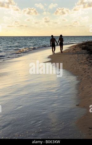 Giovane facendo una passeggiata su una spiaggia sabbiosa del resort tropicale Foto Stock