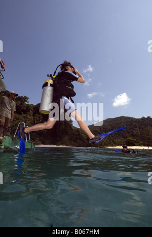 Subacqueo entrata in acqua facendo un grande passo entrata dal retro di una barca diving Foto Stock