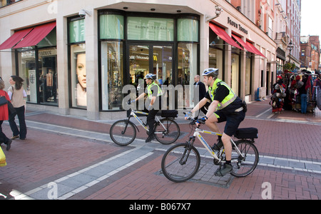 Due ufficiali della polizia in bicicletta su strada a Dublino, Irlanda Foto Stock