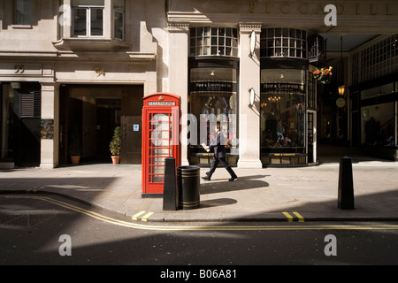 Adatto gentleman passi verso il basso Jermyn Street con il giornale in mano Foto Stock