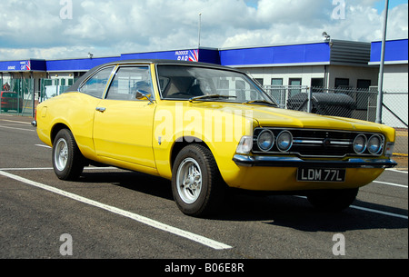 Di colore giallo brillante Ford Cortina Mk3 2000cc GT parcheggiato nel paddock di Silverstone Foto Stock