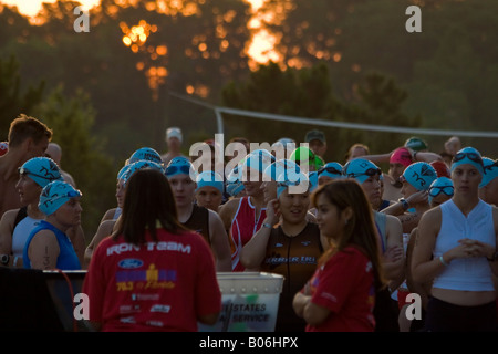 Triathlon femmina nuotatori preparando per la nuotata porzione di gara presso il Disney 70,3 Miglio Ironman in Orlando Florida Foto Stock