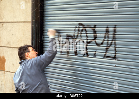 Proprietario di un negozio di pittura fuori di graffiti su shop persiane. Barcellona Spagna. Foto Stock