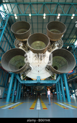 Saturn 5 razzo al Kennedy Space Center in Florida con lo zenzero donna dai capelli turistico in primo piano sopraffatte dalla dimensione del motore Foto Stock