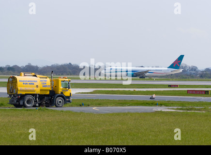 La prima scelta di Boeing 767 [767-39H ER] rullaggio dopo l'atterraggio all'Aeroporto di Manchester con Giallo spazzatrice stradale England Regno Unito Foto Stock