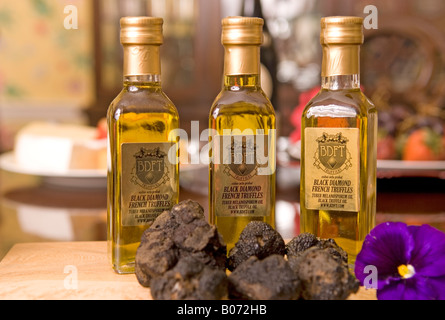 Primo piano della fresca diamante nero tartufo con tre bottiglie di olio da cucina USA Foto Stock