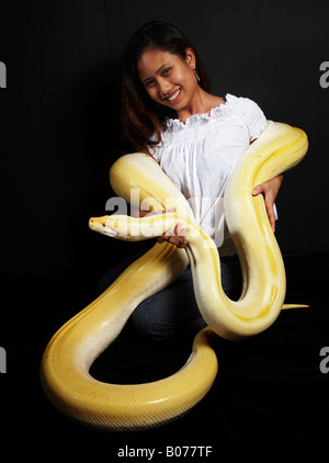 Donna con enorme Albino Python intorno a lei Foto Stock