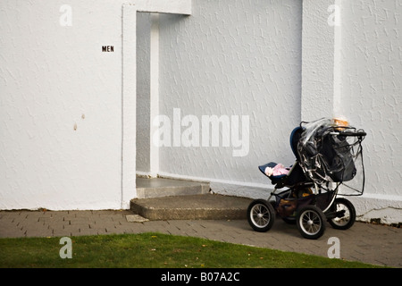 Spingere la sedia con baby sinistro esterno mens wc in un parco pubblico in Nuova Zelanda Foto Stock