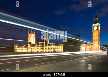 Palazzo di Westminster la sede del governo britannico con un bus accelerando da Foto Stock