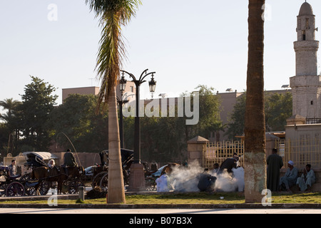 Strada locale scena di driver Caleche preparazione del tè in Midan El-Haggag sulla Sharia el-Karnak e Luxor Egitto Foto Stock