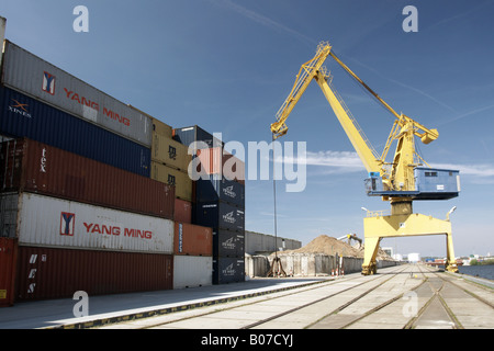Pile di contenitori di carico con gru giallo / Frachtcontainer mit Kran Foto Stock
