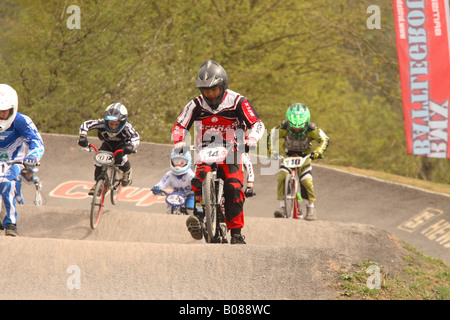 Giovani BMX bike rider i bambini a livello nazionale competizione sportiva saltare su di una rampa di Cheddar corso BMX Somerset Inghilterra Foto Stock