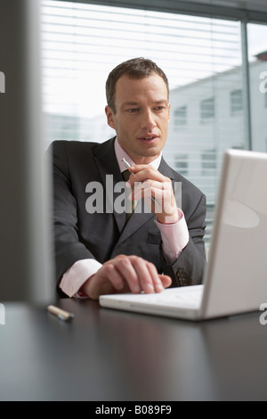 Uomo maturo seduto davanti a un computer portatile Foto Stock