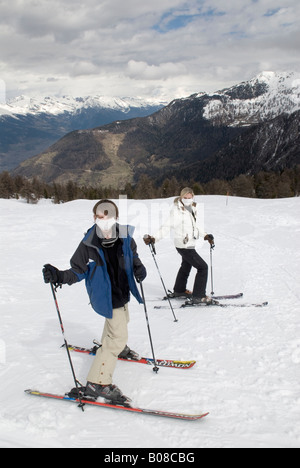 Il ragazzo e la donna che indossa le maschere di respirazione durante la pratica dello sci su una montagna Foto Stock