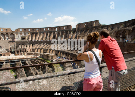 Colosseo, Roma due turisti di T shirt guardando oltre l'Arena e ipogeo Foto Stock