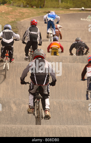 Giovani BMX bike rider i bambini a livello nazionale competizione sportiva saltare su di una rampa di Cheddar corso BMX Somerset Inghilterra Foto Stock